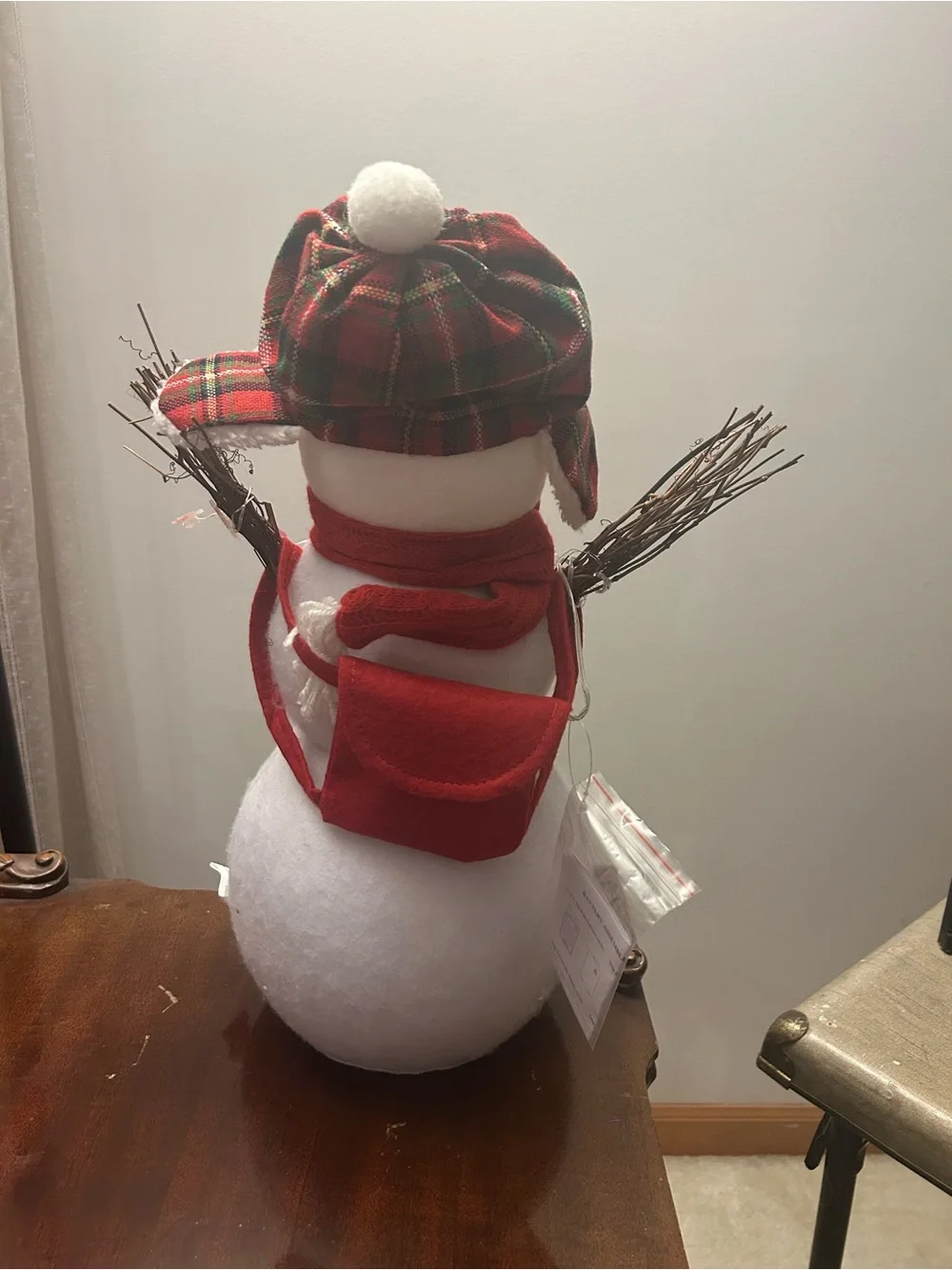 Snowman decoration with twig arms, plaid hat and Santa accent lights New